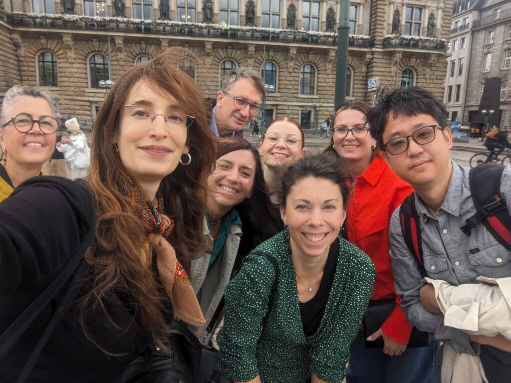 A group picture of eight people on a town square